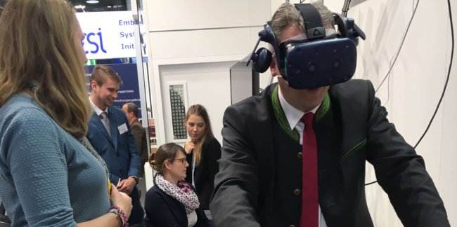 190410_HannoverMesse3 Staatssekretär Roland Weigert testet den virtuellen Fahrradhelm der THI
