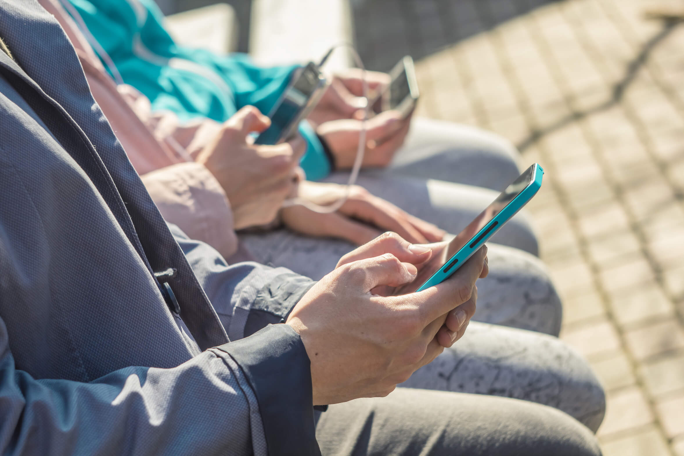 Friends. Hipsters use their phones to chat, online. Teenagers hold smart phones, write messages.