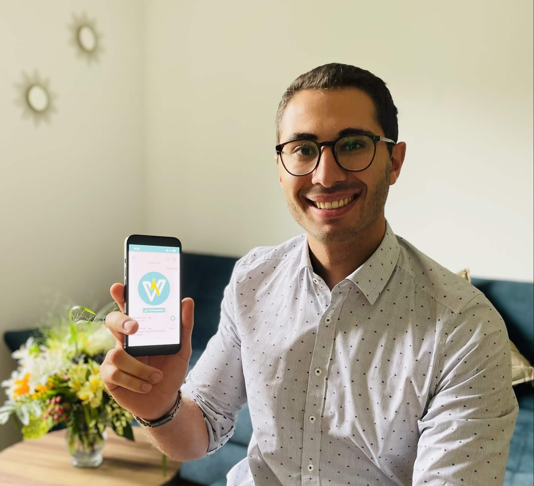 Johannes Kellner mit WiLink Das Foto zeigt Johannes Kellner. Er hält ein Smartphone mit der App "WiLink" in die Kamera.