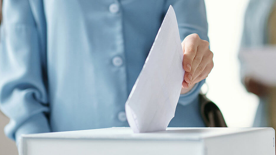 csm_COLOURBOX60926856_bbeab7edfa Ein Wahlbrief wird in eine Wahlurne gegeben.