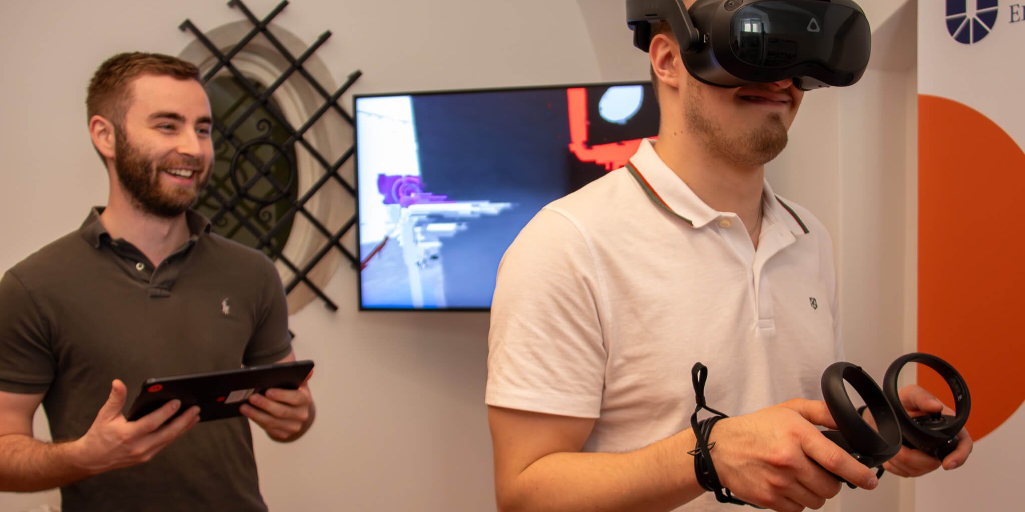 VR-Raum bei I AM AI_Foto_Laura Wagner Zu sehen sind zwei junge Männer. Einer von beiden trägt eine VR.-Brille.