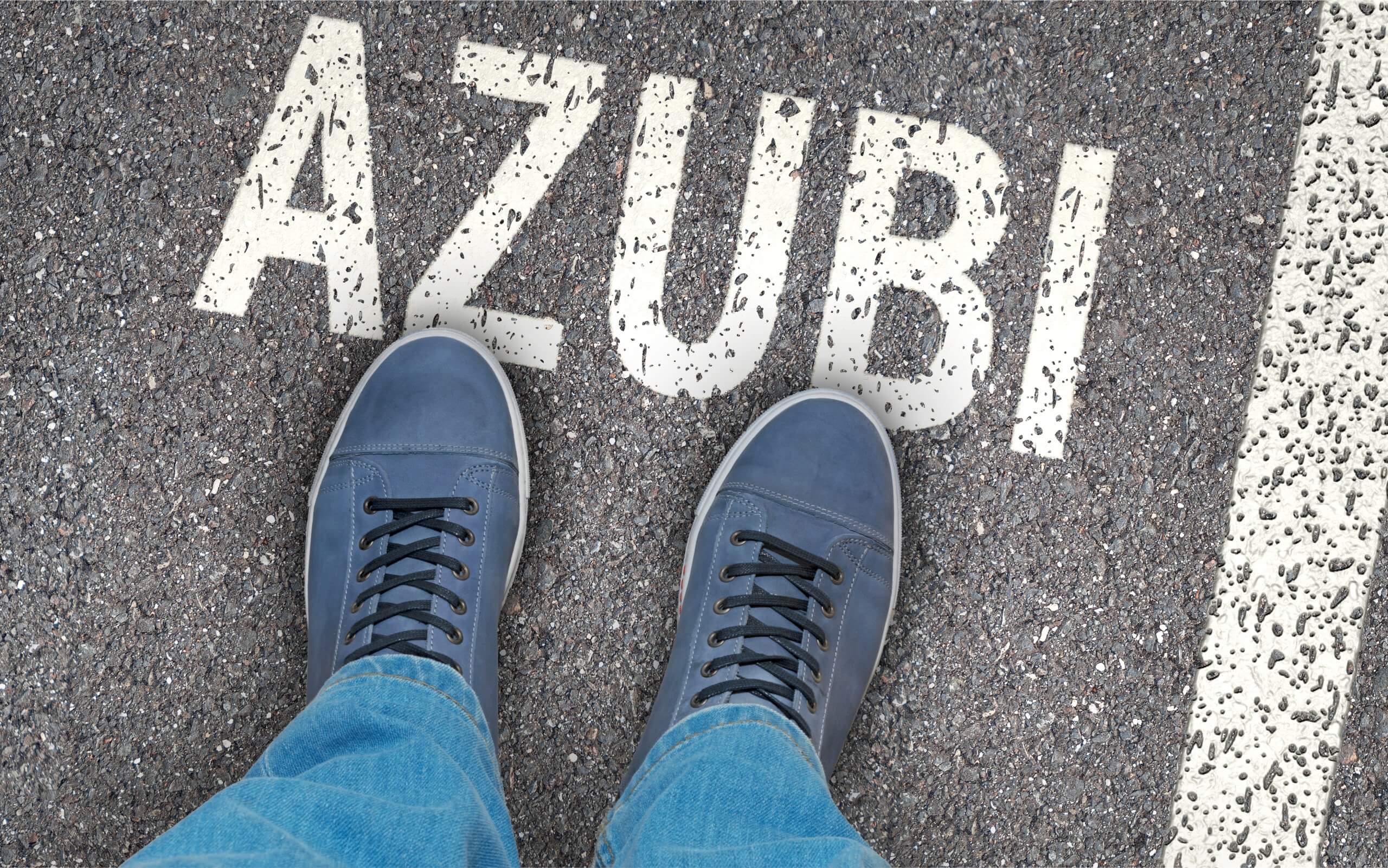 Das Foto zeigt das Wort "Azubi" auf einer Straße.