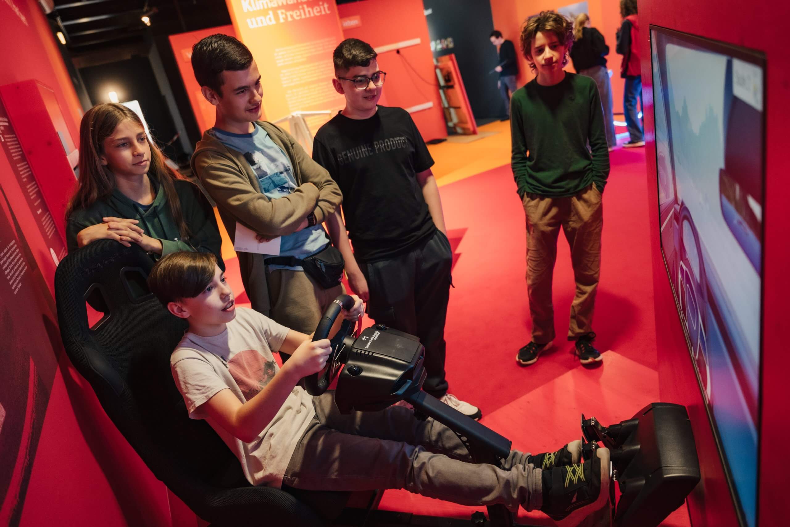 MS Wissenschaft 2024 Besucherinnen und Besucher testen den Fahrsimulator.